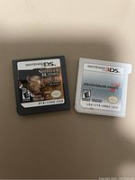 Photo showing two Nintendo game cartridges: one for Nintendo DS Sherlock Holmes game and one for Nintendo 3DS Mario Kart 7 game.