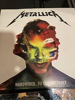 Front cover of Metallica Hardwired...To Self Destruct double vinyl LP with distorted multi-faced head artwork and Metallica logo.