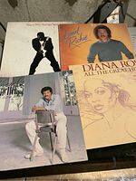 Four vinyl records including three with Lionel Richie and one featuring Diana Ross.