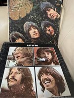 Photograph showing two Beatles vinyl record albums: Sgt. Pepper's Lonely Hearts Club Band and Let It Be, placed side by side on a light-colored surface.