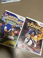 Photo showing two Nintendo Wii game cases: Sega Superstars Tennis and Sonic and the Secret Rings, both featuring Sonic the Hedgehog on the cover