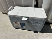 Full view of the grey Coleman Chiller cooler showing texture, side handle and hinged lid closed.