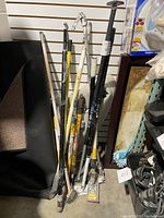 Full view of the poles gathered in a bundle, showing various lengths and colors with paint splatters and heavy wear