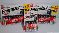 Packaged Energizer Max AA batteries, includes two 10-pack and one 4-pack unopened sealed packages with clear branding.