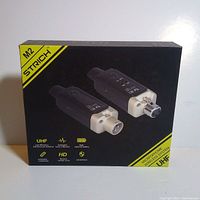 Front view of the M2 Strich UHF wireless microphone system box showing transmitter and receiver images and product features.