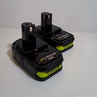 Two black and yellow lithium-ion battery packs for power tools shown side by side on a white background.