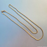 Full view of 24-inch gold chain laid out flat showing entire length and clasp