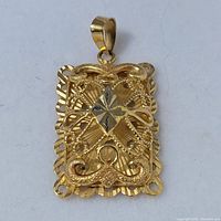 Front view of rectangular gold filigree pendant showing openwork scroll details and diamond-shaped center