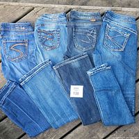 Four pairs of Silver brand women's jeans laid out side-by-side showing various washes and pocket stitching styles.