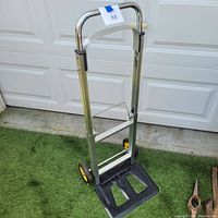 Front view of the collapsible hand truck with open platform and metal frame