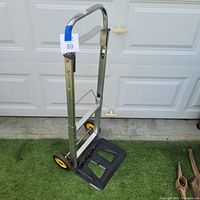 Collapsible hand truck fully extended, showing handle and black platform base.