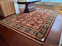 Full view of red field rug under table in living area