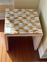 Front-left angle showing top chess board surface and side travertine base, with visible natural marble patterns and some damage.