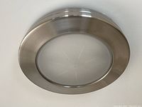 Close-up photo of one chrome flush mounted ceiling light fixture showing brushed chrome metal frame and frosted glass diffuser