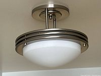 Photo of vintage style chrome ceiling light fixture showing frosted glass dome with chrome metal frame and ceiling mounting plate.