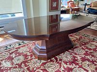 Full view of the table top showing the oval shape and walnut finish with reflective polished surface.