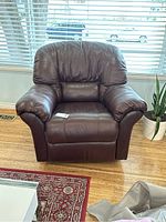 Front view of the brown pleather recliner chair showing padded backrest, armrests, and seat cushion.