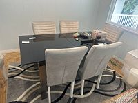 Overview of dining table with six chairs from front angle