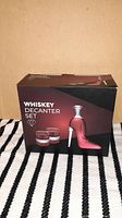 Box front showing text 'Whiskey Decanter Set' and image of red boot-shaped decanter with two glasses and stopper.