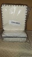 White foam floor pads packaged in clear plastic, stacked and showing interlocking jigsaw edges.