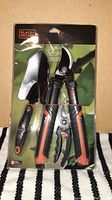 Photo of Black & Decker garden tool set in original packaging showing pruning shears and trowel with orange and black handles.
