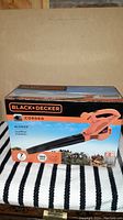 Full front view of the boxed Black+Decker corded electric leaf blower showing brand and product details.