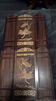 Full view of both wooden mini panels laid side by side showing detailed crane bird inlay and dark wood base with vertical grooves.