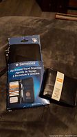 Photo of two wallets side by side on a dark surface, one in Samsonite branded packaging and the other in plastic wrap with RFID sticker.
