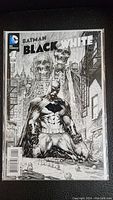 Front cover of Batman Black and White comic book issue #1, showing monochrome detailed artwork of Batman in a dark alley with skeletal figures in the background.