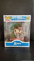 Front view of sealed Funko Pop! Kitty Pryde with Lockheed figure in original packaging showing X-Men logo and exclusive sticker.