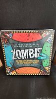 Front view of sealed Zombie Road Trip board game showing post-apocalyptic zombie survival theme and colorful design