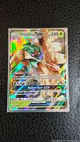 Front view of Decidueye GX holographic Pokemon card showing Pokemon image, HP, and abilities.