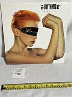 Front cover of Eurythmics vinyl album Touch featuring Annie Lennox with black blindfold and short red hair.