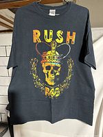 Front of the black Rush R40 concert t-shirt showing skull with crown and 'RUSH R40' text in yellow and red.