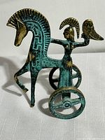 Front angle of brass sculpture showing Athena on chariot holding owl with horse rearing