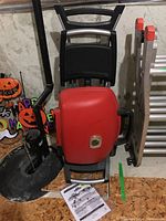 Grill folded closed from front showing wheels, handle, and base