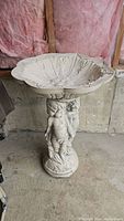 Full front view of the bird bath showing the basin and cherub pedestal.