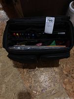 Top view inside the black craft supply bag showing colored pens and papers inside