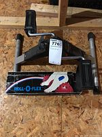 Front view of pedalling exerciser on wooden floor with branded box below