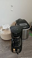 Photo showing Dometic ice maker, Nesco food dehydrator and Black and Decker coffee maker together on floor