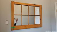 Front view of pine framed mirror showing eight sectioned glass panes and natural wood grain.