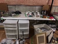 Wide view of folding table holding various items including tea cups and plates, showing overall condition and setup