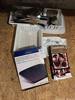 Basket with boxed 2-sided porcelain-enameled cast-iron griddle and Cuisinart oven mitt set alongside other utensils