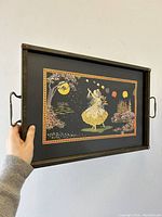 Front angle view of the metal framed serving tray with side handles showing the full illustrated design and metal border.