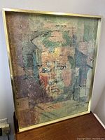 Front view of the framed abstract portrait print showing geometric cubist style composition in muted earthy tones within a thin gold-tone frame.