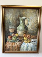 Full view of the 23" x 18.5" oil painting in a gold-toned frame featuring still life with pitcher, glass, apples on plates and cloth beneath.