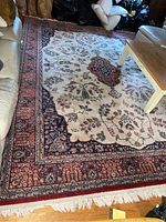 Full view of the Oriental Meched wool rug displayed on wooden floor with sofa and coffee table partially on top.