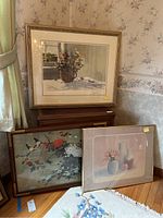 Three artworks in frames arranged against a wall, showing the variety and size comparison of the pieces