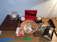 Full view of lot items including signed baseballs, golf tees, golf balls, wallet, shoe shine brush, jewelry box, lapel pins, money clips