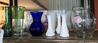 Nine assorted vintage glass vases including milk glass, colored glass, and clear glass with hand-painted designs.